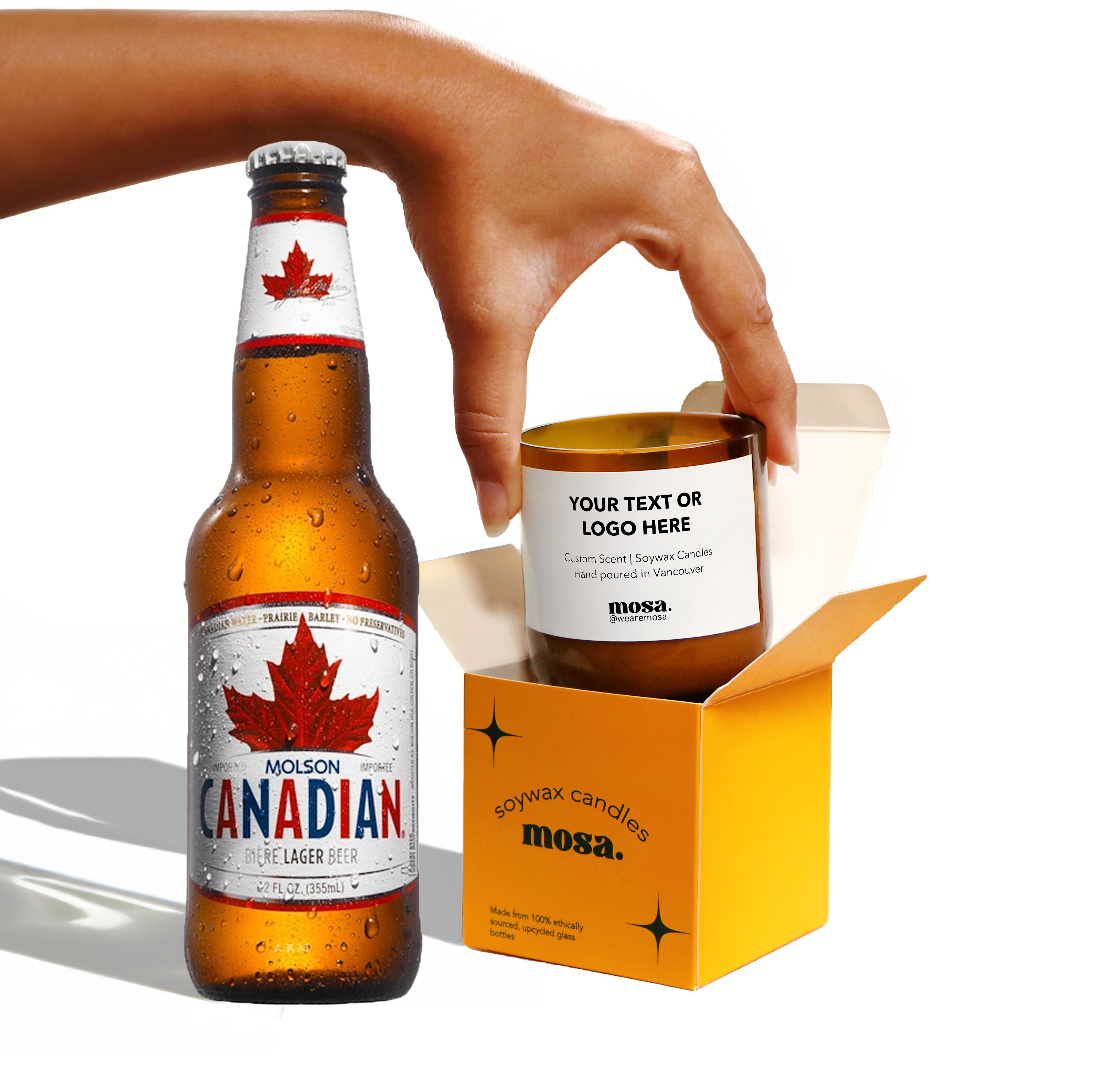Molson Canadian beer bottle with a candle in a box, hand holding the candle