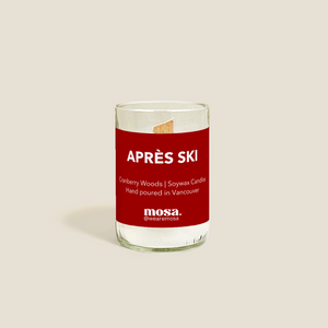 Glass candle with a red label on a beige background