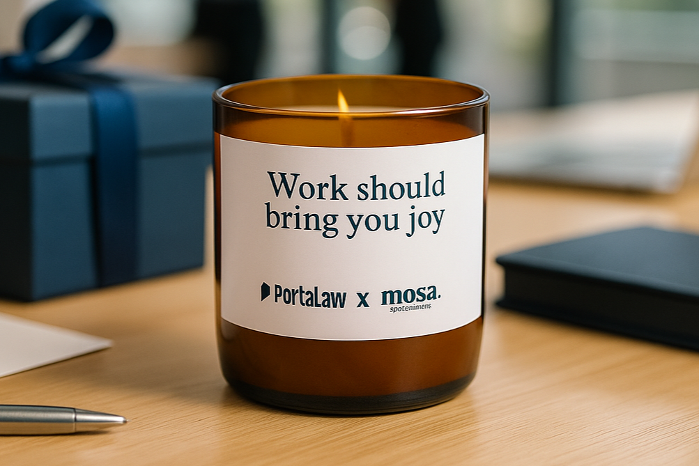 Candle with a label on a desk with a blurred office background