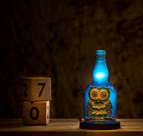 A bright blue owl lamp on a wooden table