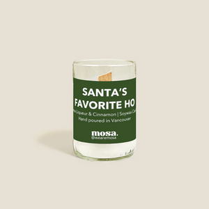 Glass candle with a green label on a beige background