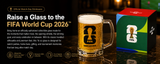 A 16 oz Vancouver 2026 FIFA World Cup collectible glass mug filled with beer, shown next to its branded retail box on a dark reflective surface. The mug features a black FIFA logo with the Vancouver skyline silhouette, and the box is red, green, and blue with FIFA branding.
