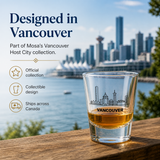 Glass with Vancouver skyline design on a wooden surface with cityscape in the background