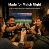 Group of people celebrating with drinks in FIFA Glasses in a living room setting, with a TV showing a sports game.