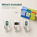 Three shot glasses with FIFA branding and a colorful gift box on a beige background.