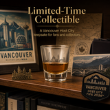 Vancouver-themed collectible items including a glass with Vancouver skyline, a patch, and a small statue on a wooden surface.