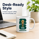 White mug with FIFA Vancouver design on a desk with laptop and notebook