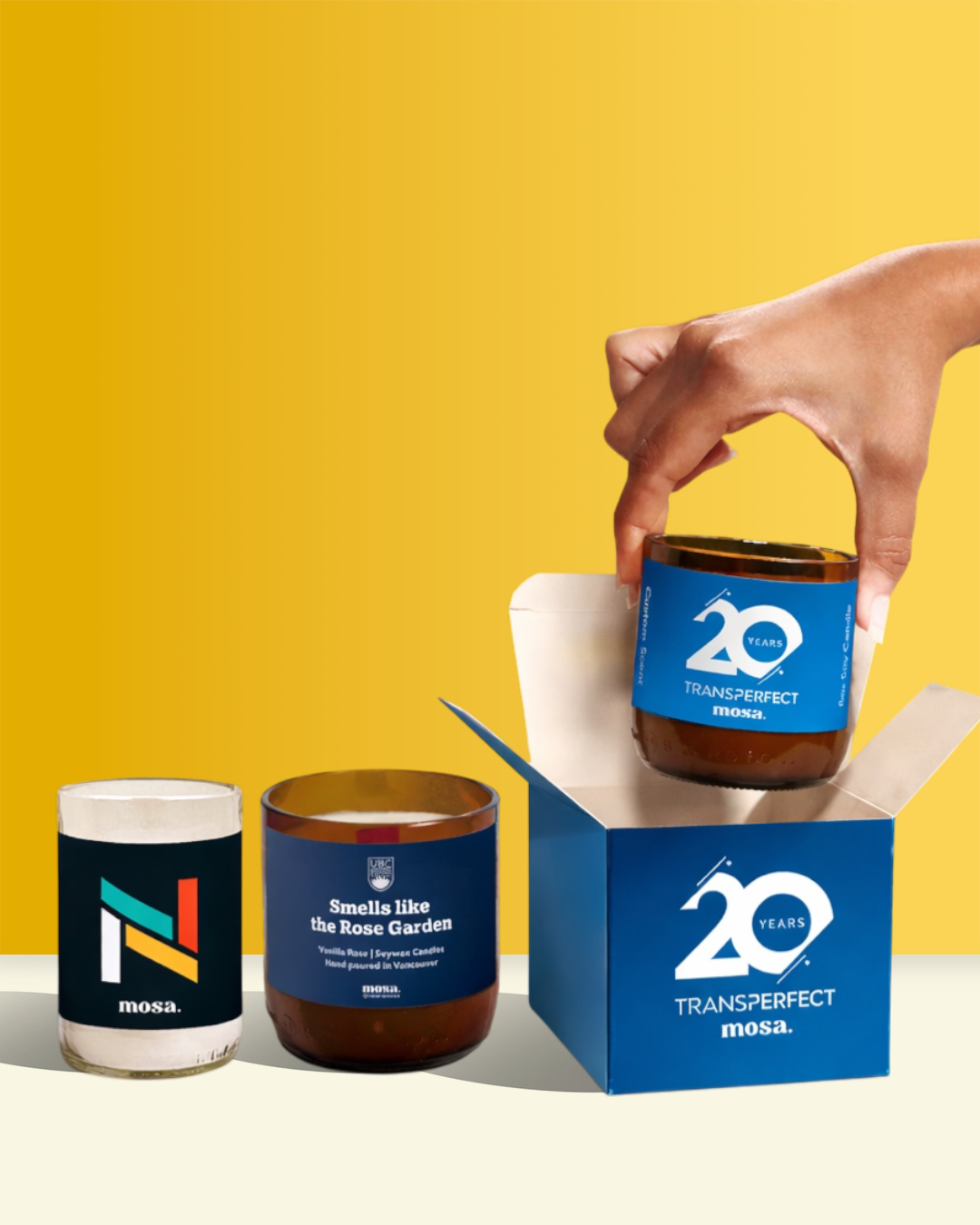 Custom Candle with 'Transperfect' branding and a hand holding another candle against a yellow background