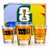 Three shot glasses with 'We Are FIFA' and 'Vancouver' text, in front of a colorful FIFA box.